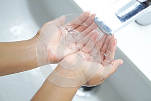 Closeup woman`s hand washing with soap in bathroom, selective focus