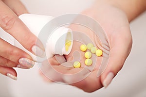 Closeup of woman`s hands holding medicine pills