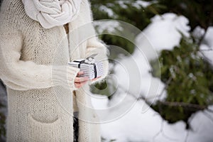 Closeup of woman`s hands holding a nice Christmas present. Outdoors. Celebration. Holidays, gifts concept