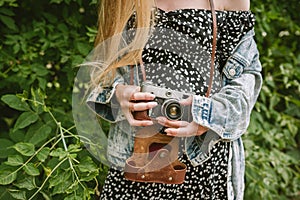 Closeup of woman`s hands holding old vintage film camera