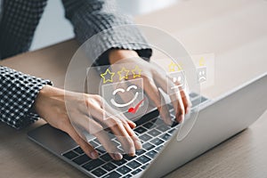 Closeup woman`s hands using laptop with checked box on happy face icon