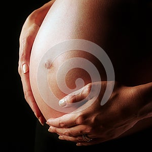 Closeup of a woman's pregnant belly.