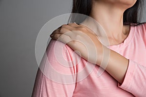Closeup woman shoulder pain and injury. Health care and medical concept