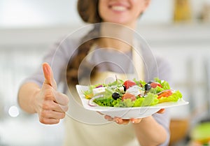 Closeup on woman showing fresh salad and thumbs up