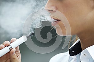 Closeup of woman smoking electronic cigarette outdoor