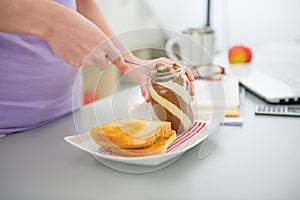 Closeup on woman spread toast with chocolate cream