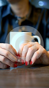 Vertical shot. closeup. the woman takes off her wedding ring sitting in a cafe