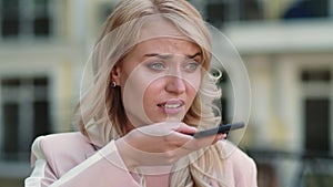 Closeup woman talking phone at street. Woman recording audio message outdoor