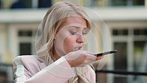 Closeup woman talking phone at street. Woman recording audio message outdoor