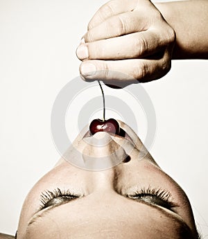 Closeup Of A Woman Tasting A Cherry