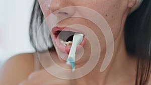 Closeup woman toothbrushing process at bath. Lady brushing teeth cleaning mouth