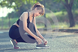 Closeup of woman tying shoe laces. Female sport fitness runner g