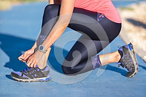 Closeup of woman tying shoe laces. Female sport fitness runner getting ready for jogging outdoors