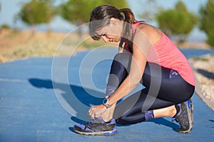 Closeup of woman tying shoe laces. Female sport fitness runner getting ready for jogging outdoors