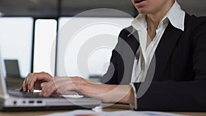 Closeup of woman typing on laptop, irritated with trouble at work, stressful job