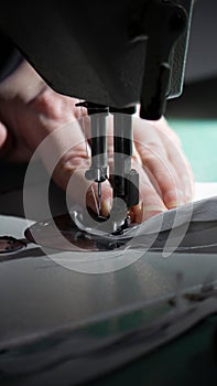 Closeup of a woman using a sewing machine to sew fabric together