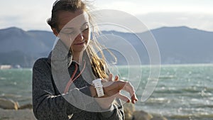 Closeup woman using smart sport running watch on the beach