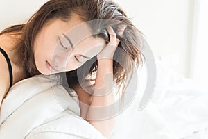 Closeup woman waking up with sore head on bed, health care and m