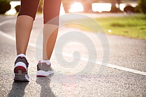 Closeup woman walking towards on the road side. Step, walk and outdoor exercise activities concept