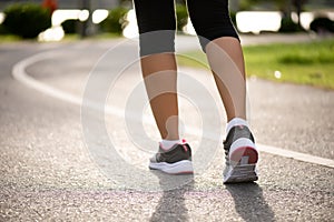 Closeup woman walking towards on the road side. Step, walk and outdoor exercise activities concept