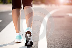 Closeup woman walking towards on the road side. Step, walk and outdoor exercise activities concept