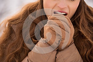 Closeup on woman warming hands with breathe in winter outdoors