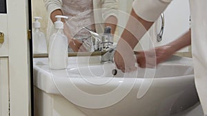 Closeup of woman washing her hands in the bathroom