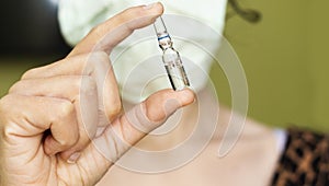 Closeup woman wear mask and holding Medical ampoules vial