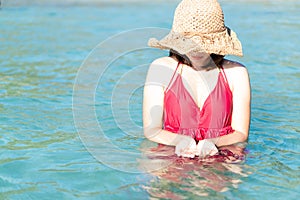 Closeup woman wearing red bikini playing sea water with happy feeling, Holiday and relax concept