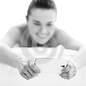 Closeup on woman writing sms while laying on massage table