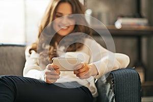 Closeup on woman writing sms in loft apartment