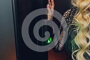 Closeup of a woman& x27;s finger entering password code on the smart digital touch screen keypad entry door lock in front of