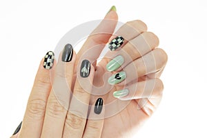 Closeup of a woman's hands with a beautiful black and grey manicure design on a white background