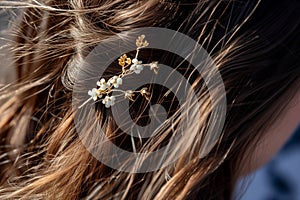 closeup of a womans hair styled with a floral hairpin accessory
