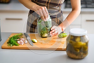 Closeup of womans hands preparing cucumbers for dill pickles