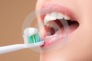 Closeup womans toothy smile against a isolated background with copy space. Girl brushing her teeth. Beautiful young