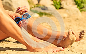 Closeup of women legs sun tanning on beach.