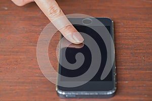 Closeup women using phone from fornt view on wood table.