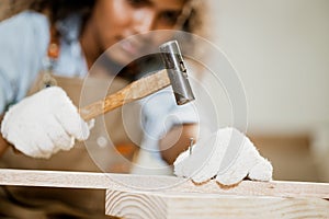 closeup wood worker carpenter use hammer tool with nails for handmade wooden furniture in workshop