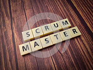 Closeup of wooden blocks spelling the words Scrum Master on a wooden background. photo