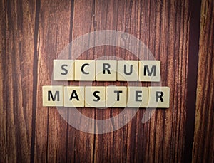 Closeup of wooden blocks spelling the words Scrum Master on a wooden background. photo