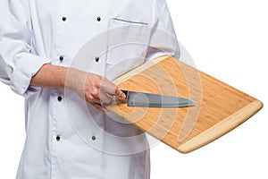 closeup of a wooden cutting board and a sharp knife in the hands