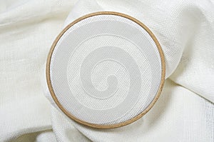 Closeup of wooden embroidery hoop and clean white fabric for hobby needlework.Empty space for design. Template for hobby design