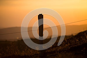 wooden fence silhouette at the top of themountain on sunset background