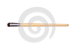 Closeup of a wooden new professional makeup brush isolated on a white background. Concept beauty. Macro photograph