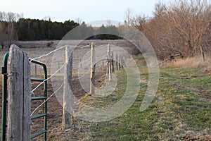 Closeup of wooden posts and wire fence on a farm