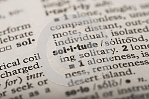 Closeup of the word `Solitude` in a dictionary