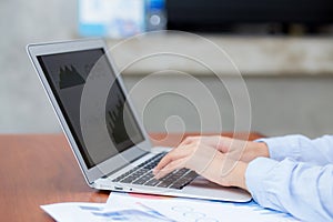 Closeup work with finance analysis and planing data on laptop, typing and paper graph with computer statistic for success