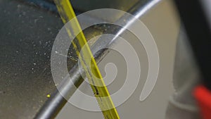 Closeup worker makes nicks with yellow hacksaw on metal side
