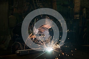 Closeup worker in a mask doing the welding in a workshop